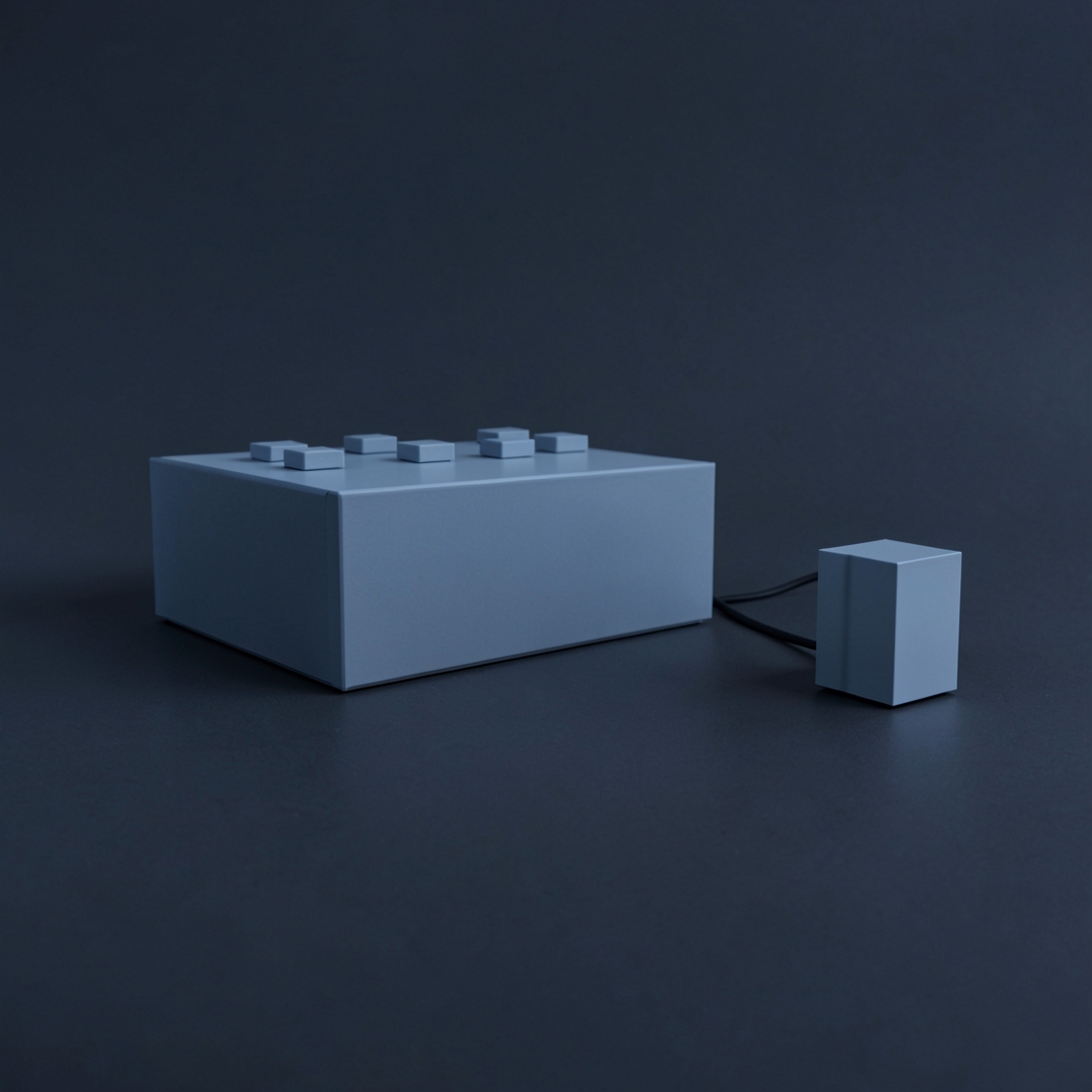 Plain scale model of a data-centre building connected by a black cable to a separate power block