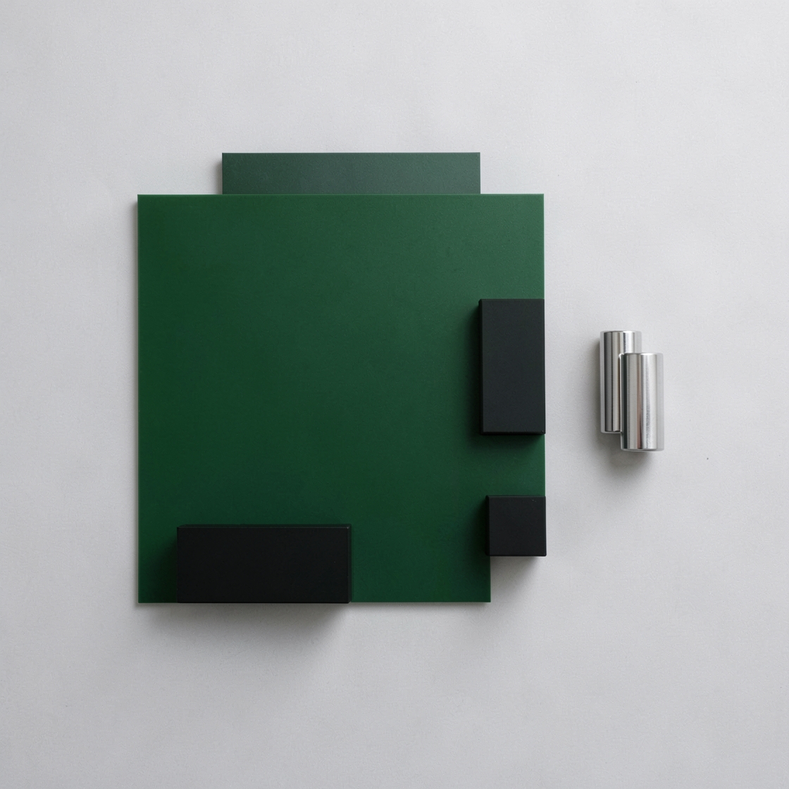Abstract green board, black blocks and silver cylinders representing retro computer construction