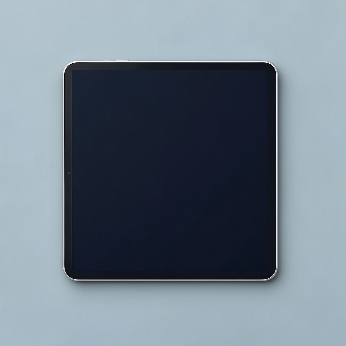 An unbranded tablet with a blank dark screen and silver edge on a pale blue surface.
