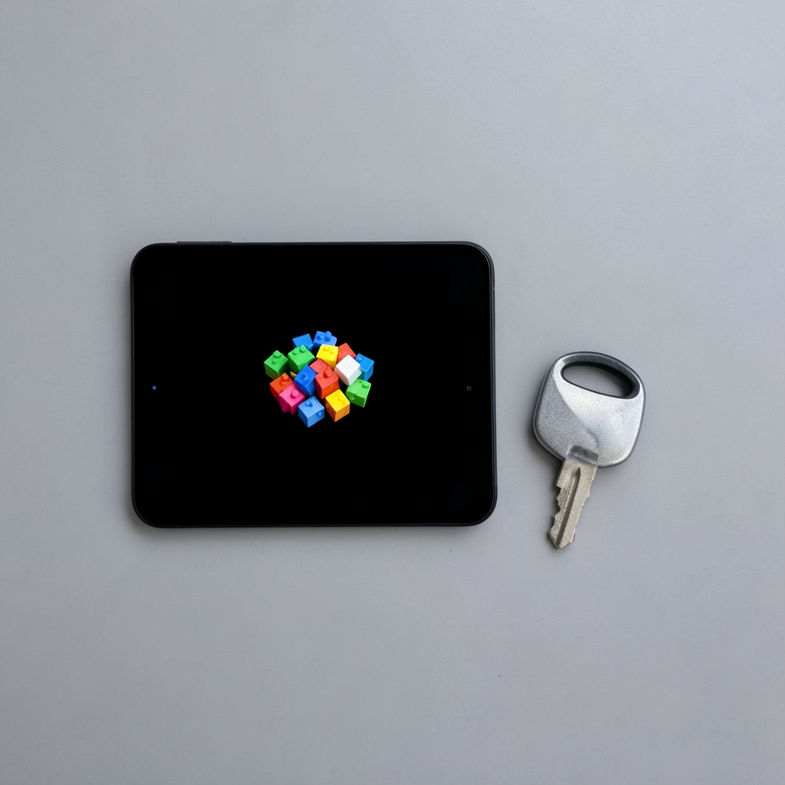Conceptual illustration of colorful blocks on a black screen beside a silver key
