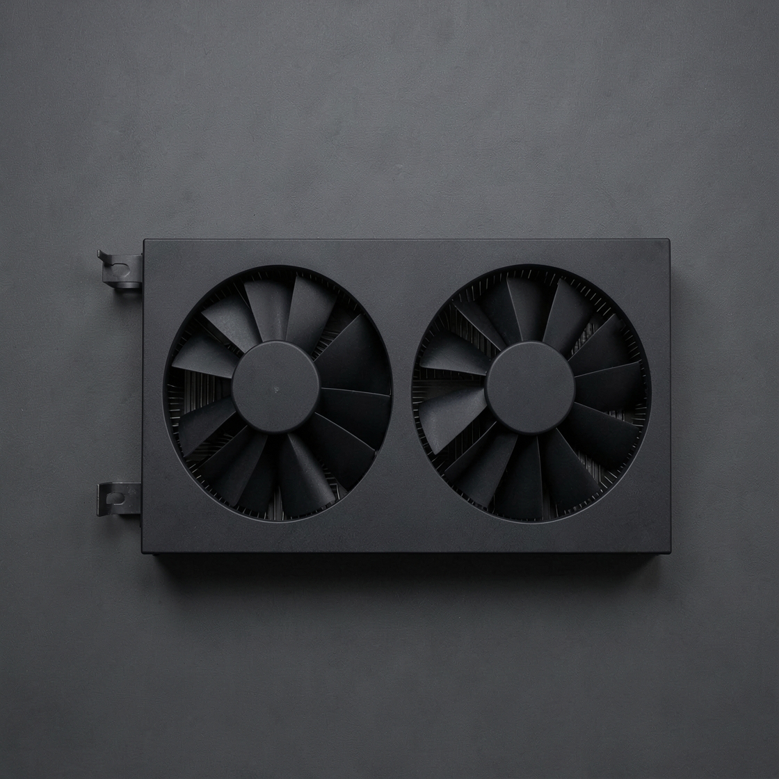 Unbranded black graphics-card cooling shroud with two fans on a grey surface